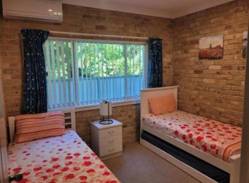 a bedroom with two beds and a window at Beachfront Escape in Forster