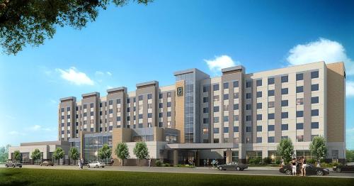 a rendering of a large building with cars parked in front at Embassy Suites By Hilton College Station in College Station