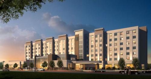 a rendering of a large building with lights on at Embassy Suites By Hilton College Station in College Station