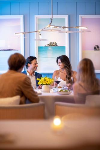 a group of people sitting around a table eating at Oceana Santa Monica, LXR Hotels & Resorts in Los Angeles