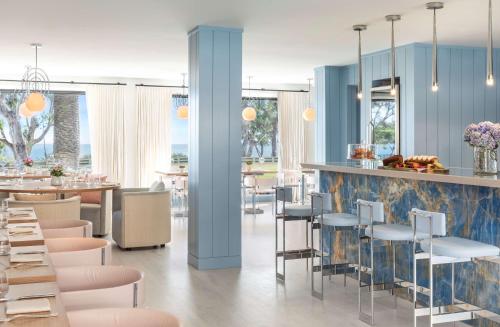 a restaurant with blue walls and tables and chairs at Oceana Santa Monica, LXR Hotels & Resorts in Los Angeles