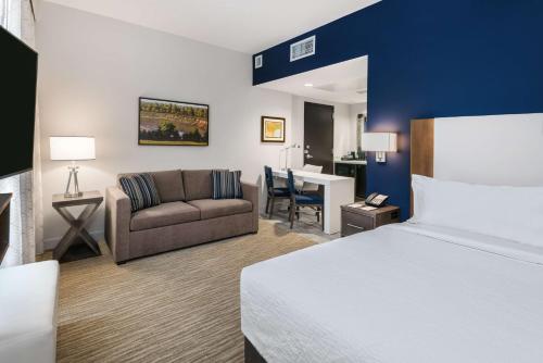a hotel room with a bed and a couch at Embassy Suites By Hilton College Station in College Station