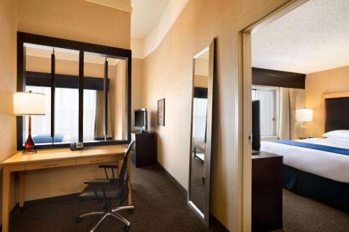 a hotel room with a desk and a bed at DoubleTree by Hilton Hotel Oklahoma City Airport in Oklahoma City