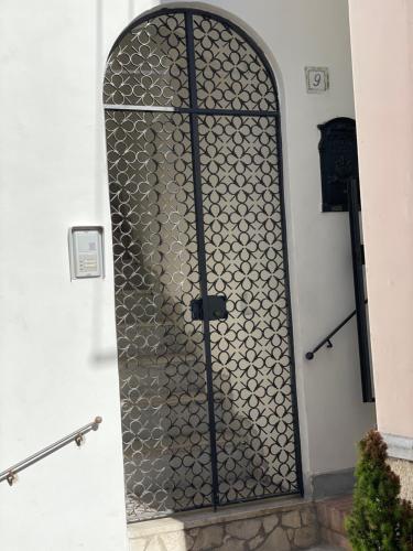 una puerta con una rejilla metálica en el lateral de un edificio en Casa Amelia, en Capri