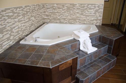 a bath tub in a bathroom with a tiled floor at Hilton Garden Inn Watertown in Watertown