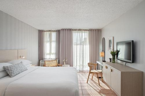 a bedroom with a bed and a desk and a television at Rincon Beach Resort in Rincon