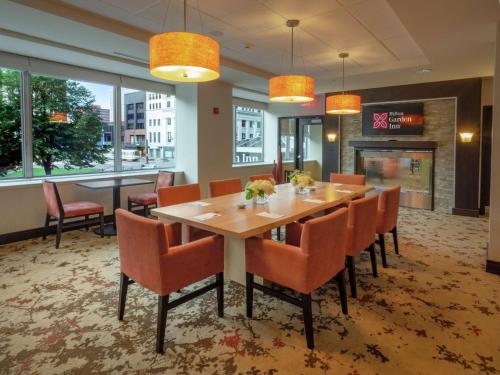 a dining room with a table and chairs at The Hilton Garden Inn Buffalo-Downtown in Buffalo