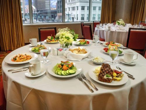 a white table with plates of food on it at The Hilton Garden Inn Buffalo-Downtown in Buffalo
