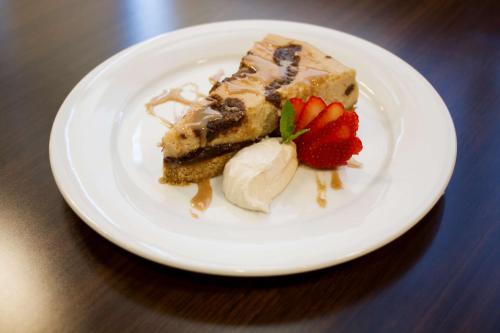 a white plate with a piece of cake and strawberries at Embassy Suites by Hilton Akron Canton Airport in North Canton
