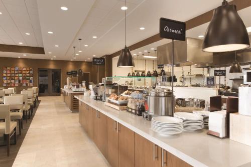 a restaurant with a counter with plates on it at Embassy Suites by Hilton Akron Canton Airport in North Canton