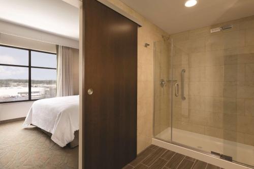 1 dormitorio con 1 cama y baño con ducha. en Embassy Suites by Hilton Akron Canton Airport en North Canton