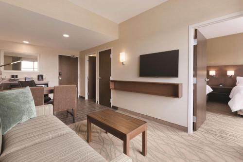a living room with a couch and a tv at Embassy Suites by Hilton Akron Canton Airport in North Canton