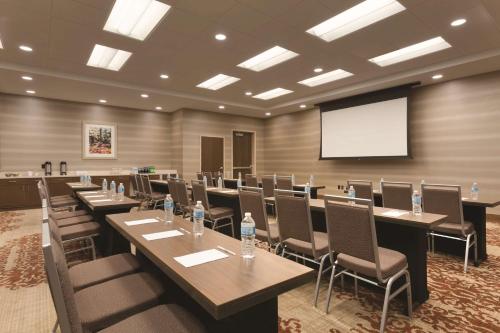 a conference room with tables and chairs and a screen at Embassy Suites by Hilton Akron Canton Airport in North Canton