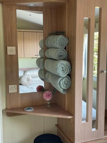 a bathroom with a stack of towels in front of a mirror at Sea View Fields Trearddur in Holyhead