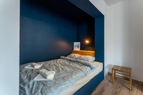 a bedroom with blue walls and a bed with pillows at Apartament Wolności Lubomierz in Lubomierz