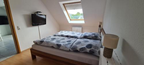 Dormitorio pequeño con cama y TV en Ferienwohnung Emmerthal, en Emmerthal