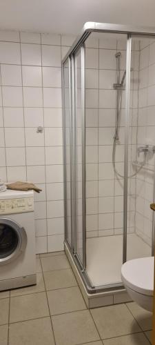 y baño con ducha y lavadora. en Ferienwohnung Emmerthal, en Emmerthal