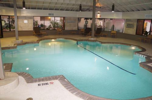 a large swimming pool with blue water in a building at Embassy Suites Corpus Christi in Corpus Christi