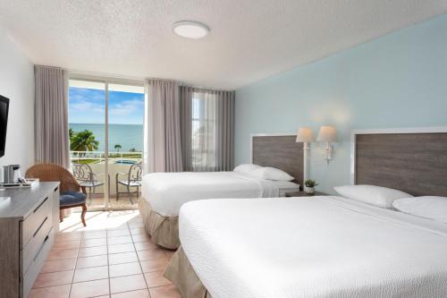 a hotel room with two beds and a balcony at Rincon Beach Resort in Rincon