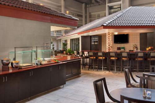 a restaurant with a bar and some tables and chairs at Embassy Suites Corpus Christi in Corpus Christi