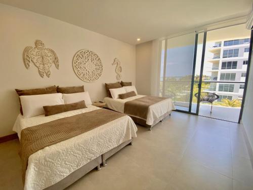 ein Hotelzimmer mit 2 Betten und einem Balkon in der Unterkunft Apartamento de Lujo Morros Zóe - Manzanillo - Cartagena in Cartagena de Indias