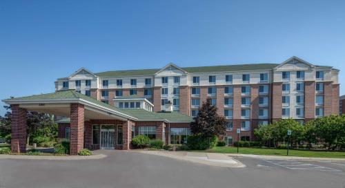 a large brick building with a parking lot in front of it at Hilton Garden Inn Detroit Metro Airport in Romulus