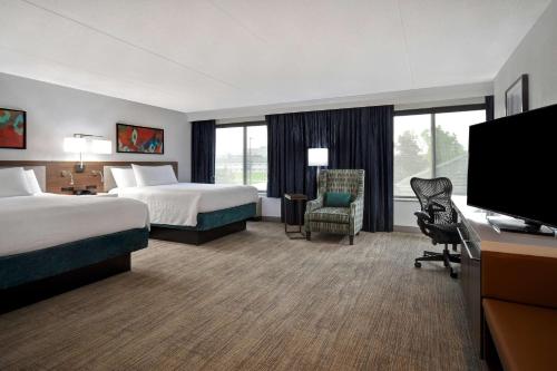 um quarto de hotel com duas camas e uma televisão de ecrã plano em Hilton Garden Inn Detroit Metro Airport em Romulus