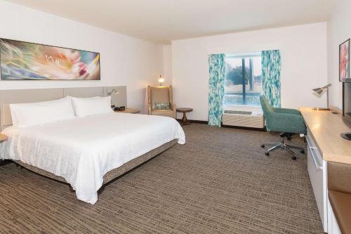a hotel room with a bed and a desk and a computer at Hilton Garden Inn Daytona Beach Airport in Daytona Beach