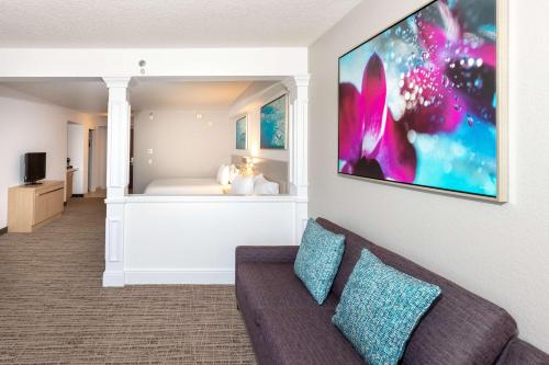 a living room with a couch and a bedroom at Hilton Garden Inn Daytona Beach Airport in Daytona Beach