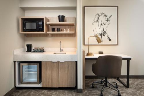 a kitchen with a desk and a sink and a chair at SpringHill Suites by Marriott Dallas Downtown / West End in Dallas