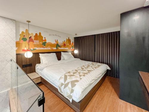 Schlafzimmer mit einem Bett mit Wandgemälde in der Unterkunft Fouralivin in Kesiman