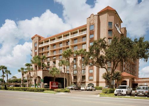 a large building with cars parked in front of it at Doubletree by Hilton McAllen in McAllen