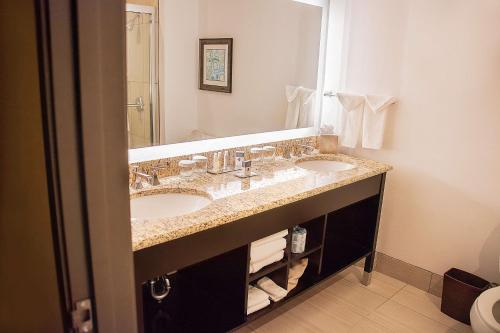 a bathroom with two sinks and a large mirror at Doubletree by Hilton McAllen in McAllen