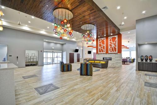 an open lobby with a large room with wood floors and chandeliers at Homewood Suites by Hilton Orlando Theme Parks in Orlando