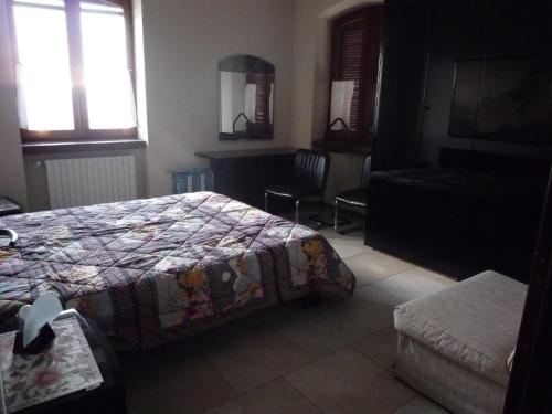 a bedroom with a bed and a chair and a window at La Vigna Del Parroco in Verduno
