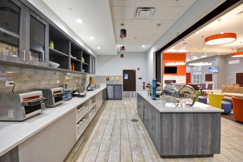 a large kitchen with a counter in a restaurant at Homewood Suites by Hilton Orlando Theme Parks in Orlando