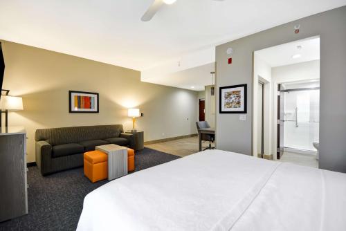 オーランドにあるホームウッド スイーツ バイ ヒルトン オーランド テーマ パークスのベッドとソファ付きのホテルルーム