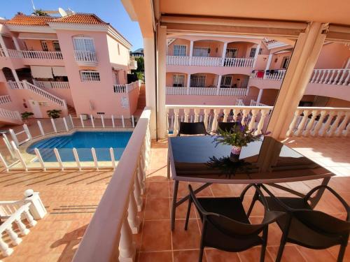 - un balcon dans un immeuble avec une table et une piscine dans l'établissement Apartamento en Callao Salvaje, à Callao Salvaje