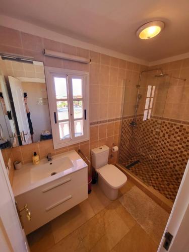 La salle de bains est pourvue d'un lavabo, de toilettes et d'une douche. dans l'établissement Apartamento en Callao Salvaje, à Callao Salvaje