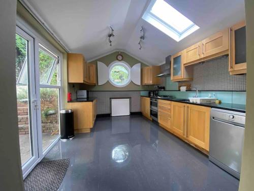 a large kitchen with wooden cabinets and a window at Elegant flat in a fantastic area in London