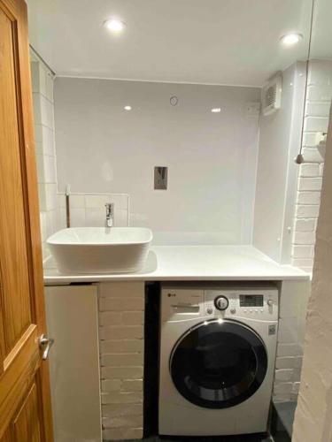 a kitchen with a washing machine and a sink at Elegant flat in a fantastic area in London