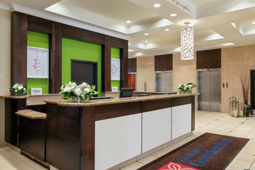 a lobby with a reception desk and green walls at Hilton Garden Inn Saskatoon Downtown in Saskatoon