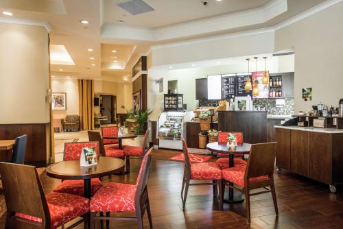 a restaurant with tables and chairs and a counter at Hilton Garden Inn Saskatoon Downtown in Saskatoon