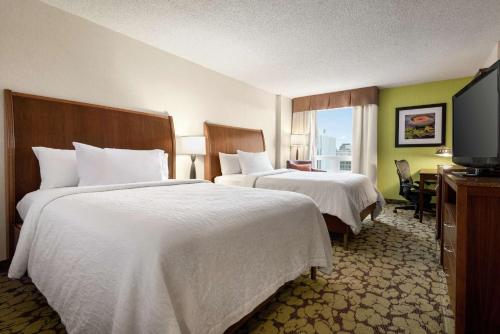 a hotel room with two beds and a flat screen tv at Hilton Garden Inn Saskatoon Downtown in Saskatoon