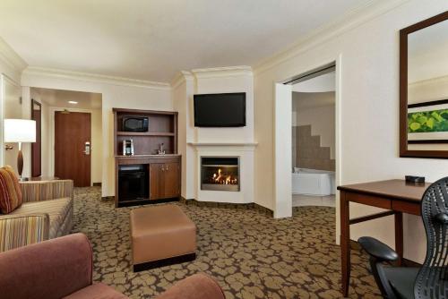 a hotel room with a living room with a fireplace at Hilton Garden Inn Saskatoon Downtown in Saskatoon