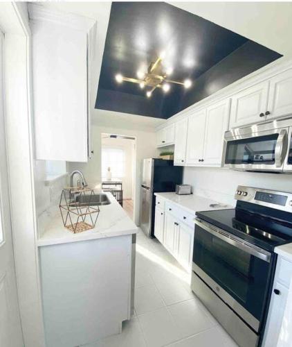 a kitchen with white cabinets and a black stove top oven at Crown Point Home w/ Cowboy Pool 2 Blocks to Bay in San Diego