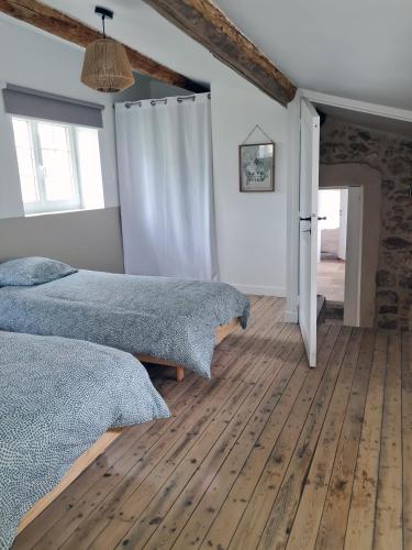 une chambre avec deux lits et un parquet dans l'établissement Maison provençale, jardin arboré et terrasses proche Grignan 8-10pers, à Réauville