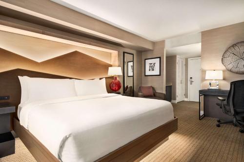 a hotel room with a large bed and a desk at Hilton Vancouver Airport in Richmond