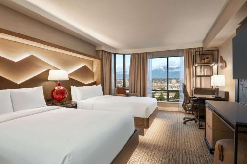 リッチモンドにあるヒルトン バンクーバー エアポートのベッド2台とデスクが備わるホテルルームです。