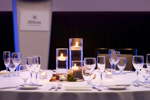 a table with wine glasses and candles on it at Hilton Vancouver Airport in Richmond